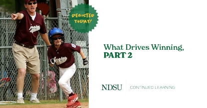 Young boy in baseball uniform running with coach in background pointing
